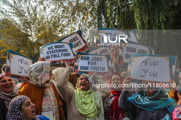 Female workers of the Jammu and Kashmir Pradesh Congress Committee (JKPCC) shout slogans and hold placards during a protest demanding the re...