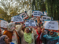 Female workers of the Jammu and Kashmir Pradesh Congress Committee (JKPCC) shout slogans and hold placards during a protest demanding the re...