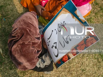 A child holds a placard during a protest demanding the restoration of statehood and constitutional guarantees in Srinagar, Jammu and Kashmir...