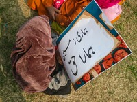 A child holds a placard during a protest demanding the restoration of statehood and constitutional guarantees in Srinagar, Jammu and Kashmir...