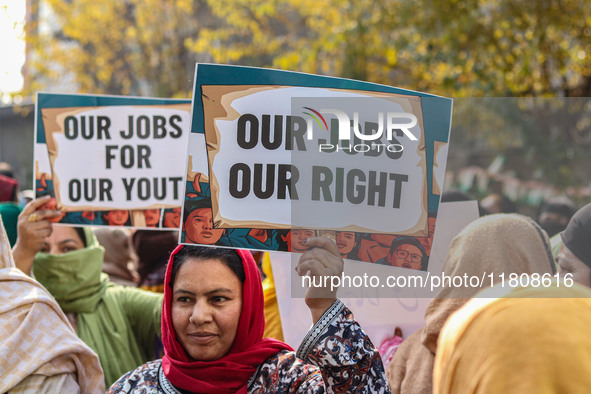 A female worker of the Jammu and Kashmir Pradesh Congress Committee (JKPCC) holds a placard during a protest demanding the restoration of st...