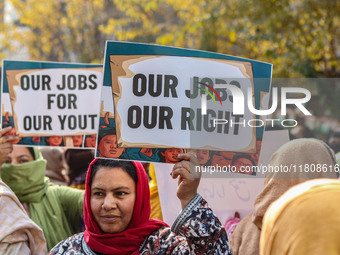 A female worker of the Jammu and Kashmir Pradesh Congress Committee (JKPCC) holds a placard during a protest demanding the restoration of st...