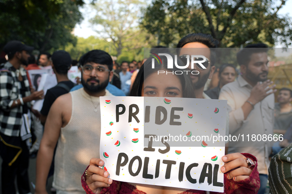 An LGBT supporter holds a placard reading 'pride is political' during the pride march in New Delhi, India, on November 24, 2024. 