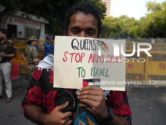 A member of the LGBT community holds a placard demanding an end to the arms sale to Israel at the pride march in New Delhi, India, on Novemb...