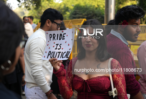 An LGBT supporter holds a placard reading 'pride is political' during the pride march in New Delhi, India, on November 24, 2024. 