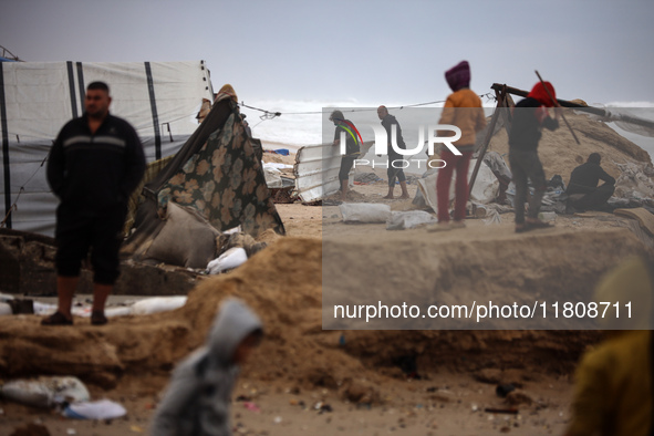 Palestinian displaced persons inspect their tents, which are damaged by wind and rain after heavy rainfall in Deir al-Balah, central Gaza St...