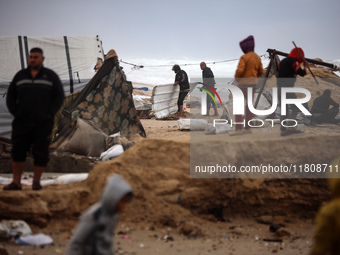 Palestinian displaced persons inspect their tents, which are damaged by wind and rain after heavy rainfall in Deir al-Balah, central Gaza St...