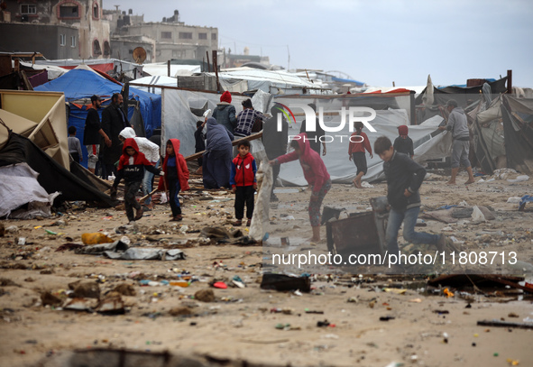 Palestinian displaced persons inspect their tents, which are damaged by wind and rain after heavy rainfall in Deir al-Balah, central Gaza St...