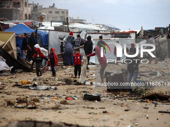 Palestinian displaced persons inspect their tents, which are damaged by wind and rain after heavy rainfall in Deir al-Balah, central Gaza St...