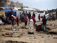 Palestinian displaced persons inspect their tents, which are damaged by wind and rain after heavy rainfall in Deir al-Balah, central Gaza St...