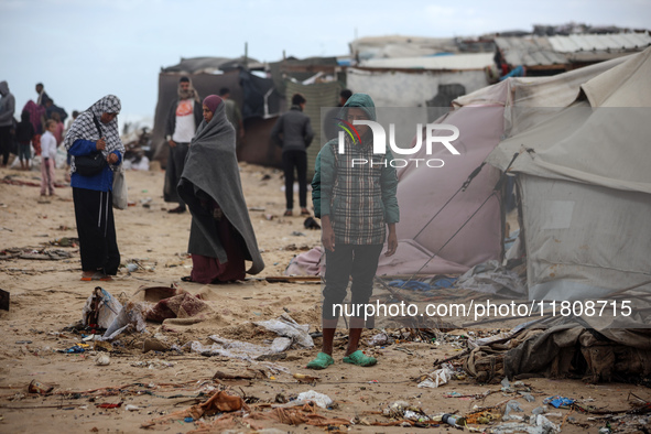 Palestinian displaced persons inspect their tents, which are damaged by wind and rain after heavy rainfall in Deir al-Balah, central Gaza St...