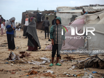 Palestinian displaced persons inspect their tents, which are damaged by wind and rain after heavy rainfall in Deir al-Balah, central Gaza St...