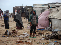 Palestinian displaced persons inspect their tents, which are damaged by wind and rain after heavy rainfall in Deir al-Balah, central Gaza St...