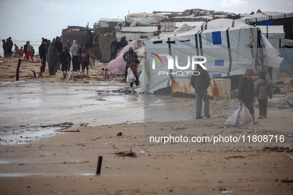 Palestinian displaced persons inspect their tents, which are damaged by wind and rain after heavy rainfall in Deir al-Balah, central Gaza St...