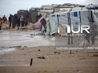 Palestinian displaced persons inspect their tents, which are damaged by wind and rain after heavy rainfall in Deir al-Balah, central Gaza St...