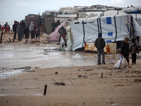 Palestinian displaced persons inspect their tents, which are damaged by wind and rain after heavy rainfall in Deir al-Balah, central Gaza St...