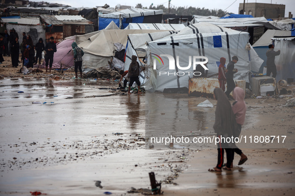 Palestinian displaced persons inspect their tents, which are damaged by wind and rain after heavy rainfall in Deir al-Balah, central Gaza St...