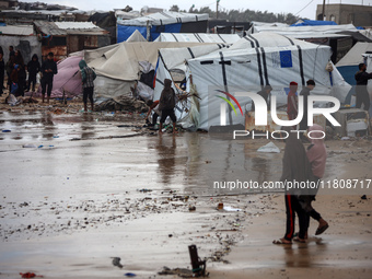 Palestinian displaced persons inspect their tents, which are damaged by wind and rain after heavy rainfall in Deir al-Balah, central Gaza St...