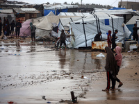 Palestinian displaced persons inspect their tents, which are damaged by wind and rain after heavy rainfall in Deir al-Balah, central Gaza St...