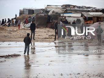 Palestinian displaced persons inspect their tents, which are damaged by wind and rain after heavy rainfall in Deir al-Balah, central Gaza St...