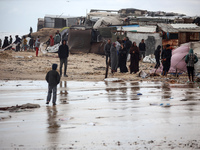 Palestinian displaced persons inspect their tents, which are damaged by wind and rain after heavy rainfall in Deir al-Balah, central Gaza St...