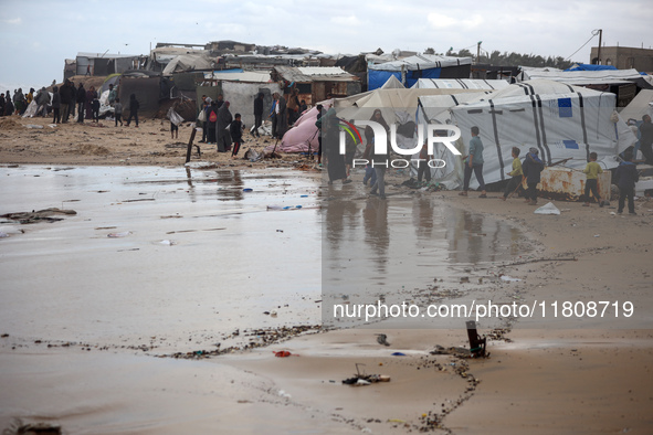 Palestinian displaced persons inspect their tents, which are damaged by wind and rain after heavy rainfall in Deir al-Balah, central Gaza St...