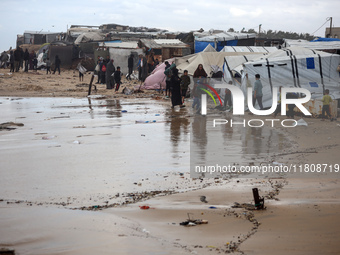 Palestinian displaced persons inspect their tents, which are damaged by wind and rain after heavy rainfall in Deir al-Balah, central Gaza St...