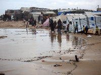 Palestinian displaced persons inspect their tents, which are damaged by wind and rain after heavy rainfall in Deir al-Balah, central Gaza St...