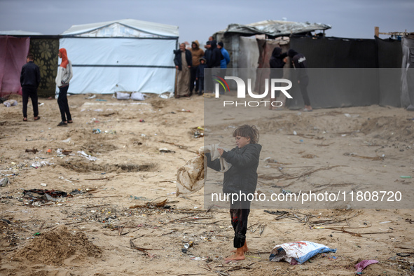 Palestinian displaced persons inspect their tents, which are damaged by wind and rain after heavy rainfall in Deir al-Balah, central Gaza St...