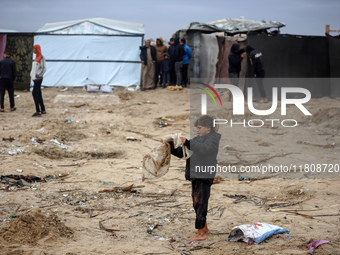 Palestinian displaced persons inspect their tents, which are damaged by wind and rain after heavy rainfall in Deir al-Balah, central Gaza St...