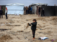 Palestinian displaced persons inspect their tents, which are damaged by wind and rain after heavy rainfall in Deir al-Balah, central Gaza St...