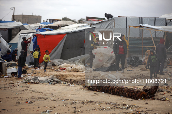 Palestinian displaced persons inspect their tents, which are damaged by wind and rain after heavy rainfall in Deir al-Balah, central Gaza St...