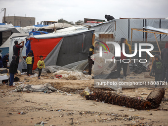 Palestinian displaced persons inspect their tents, which are damaged by wind and rain after heavy rainfall in Deir al-Balah, central Gaza St...