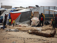 Palestinian displaced persons inspect their tents, which are damaged by wind and rain after heavy rainfall in Deir al-Balah, central Gaza St...