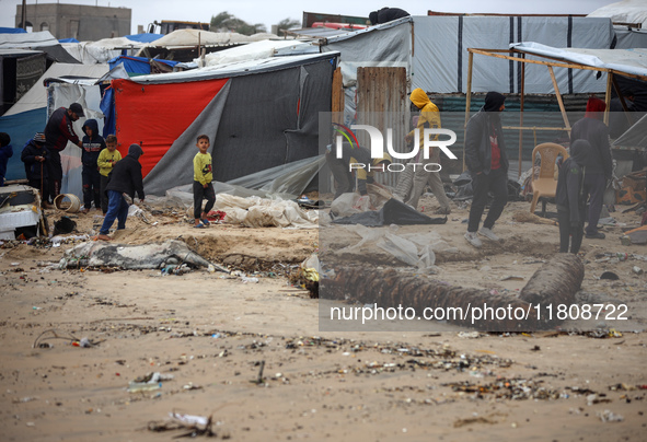 Palestinian displaced persons inspect their tents, which are damaged by wind and rain after heavy rainfall in Deir al-Balah, central Gaza St...