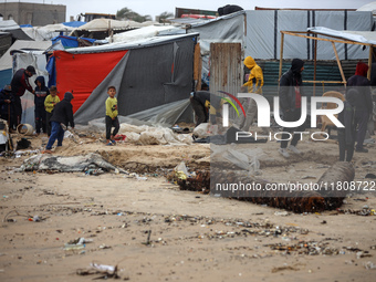 Palestinian displaced persons inspect their tents, which are damaged by wind and rain after heavy rainfall in Deir al-Balah, central Gaza St...