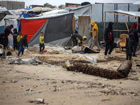 Palestinian displaced persons inspect their tents, which are damaged by wind and rain after heavy rainfall in Deir al-Balah, central Gaza St...