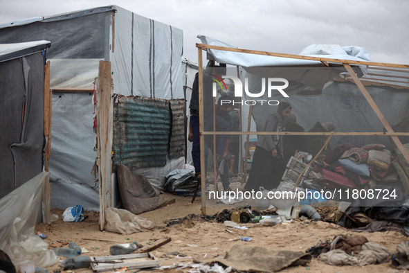 Palestinian displaced persons inspect their tents, which are damaged by wind and rain after heavy rainfall in Deir al-Balah, central Gaza St...