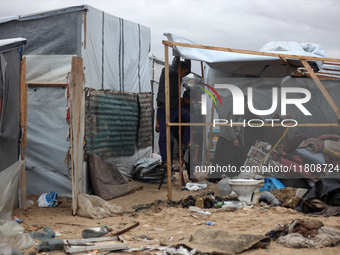 Palestinian displaced persons inspect their tents, which are damaged by wind and rain after heavy rainfall in Deir al-Balah, central Gaza St...