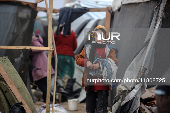 Palestinian displaced persons inspect their tents, which are damaged by wind and rain after heavy rainfall in Deir al-Balah, central Gaza St...