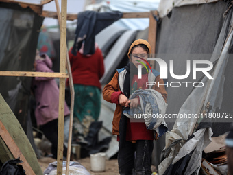 Palestinian displaced persons inspect their tents, which are damaged by wind and rain after heavy rainfall in Deir al-Balah, central Gaza St...