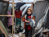 Palestinian displaced persons inspect their tents, which are damaged by wind and rain after heavy rainfall in Deir al-Balah, central Gaza St...