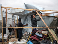 Palestinian displaced persons inspect their tents, which are damaged by wind and rain after heavy rainfall in Deir al-Balah, central Gaza St...