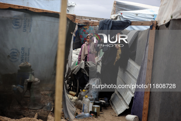 Palestinian displaced persons inspect their tents, which are damaged by wind and rain after heavy rainfall in Deir al-Balah, central Gaza St...