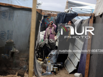 Palestinian displaced persons inspect their tents, which are damaged by wind and rain after heavy rainfall in Deir al-Balah, central Gaza St...