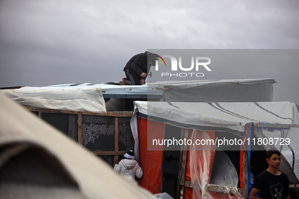 Palestinian displaced persons inspect their tents, which are damaged by wind and rain after heavy rainfall in Deir al-Balah, central Gaza St...