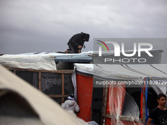 Palestinian displaced persons inspect their tents, which are damaged by wind and rain after heavy rainfall in Deir al-Balah, central Gaza St...