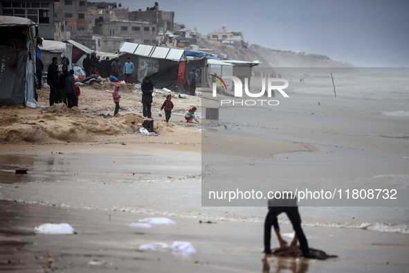 Palestinian displaced persons inspect their tents, which are damaged by wind and rain after heavy rainfall in Deir al-Balah, central Gaza St...