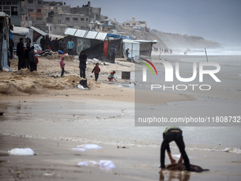 Palestinian displaced persons inspect their tents, which are damaged by wind and rain after heavy rainfall in Deir al-Balah, central Gaza St...