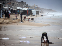 Palestinian displaced persons inspect their tents, which are damaged by wind and rain after heavy rainfall in Deir al-Balah, central Gaza St...